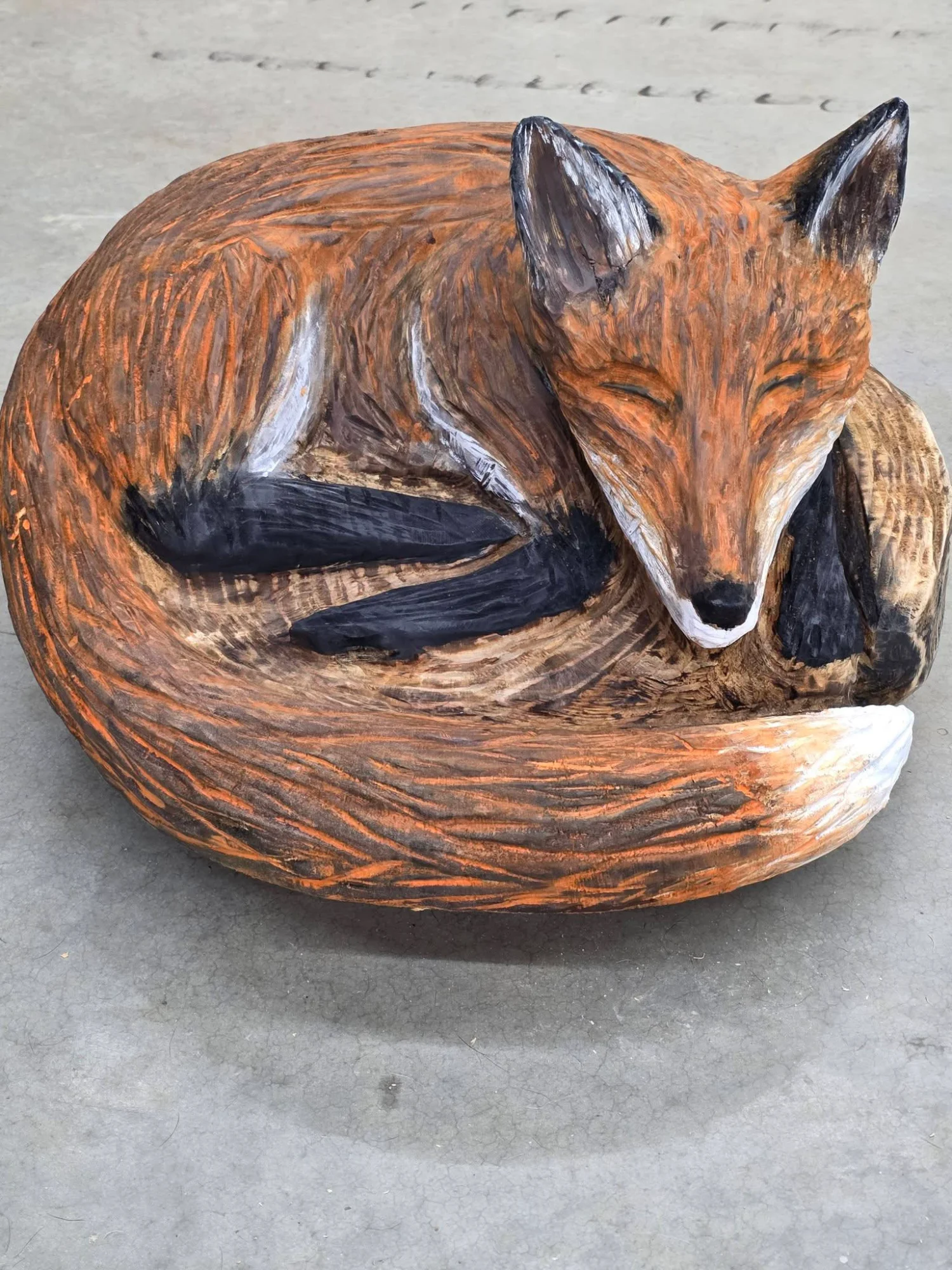 Sleeping Red Fox chainsaw carving curled up with tail wrapped around body